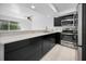 Open kitchen with bar, stainless steel appliances, dark cabinets, and quartz countertops at 985 Wellington Ct, Dunedin, FL 34698