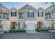 Charming townhomes featuring individual garages, quaint balconies, and landscaped surroundings at 985 Wellington Ct, Dunedin, FL 34698
