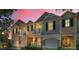 View of townhomes at dusk, each with a garage and balcony, under a colorful sky at 985 Wellington Ct, Dunedin, FL 34698