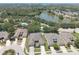 Aerial view highlights homes by a lake, with mature trees, a swimming pool, and neighborhood street layout at 1023 Orca Ct, Holiday, FL 34691