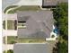 Aerial view of a well-manicured house, showing the roof, backyard patio, landscaping, and nearby greenery at 1023 Orca Ct, Holiday, FL 34691