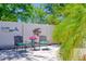 Backyard patio with a pair of chairs, a small flower table and manicured landscaping at 1023 Orca Ct, Holiday, FL 34691