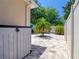 Fenced-in backyard featuring a large paved area with decorative stone accents and lush tropical greenery at 1023 Orca Ct, Holiday, FL 34691