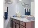Well-lit bathroom featuring granite countertops, ample cabinet space, and decorative marine-themed decor at 1023 Orca Ct, Holiday, FL 34691