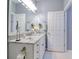 Bathroom with marble countertop vanity, decorative mirror, and white painted cabinets at 1023 Orca Ct, Holiday, FL 34691