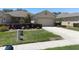 Well-maintained home exterior with lush landscaping, a manicured lawn, and a paved driveway at 1023 Orca Ct, Holiday, FL 34691