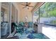 Inviting lanai with sliding glass doors, a ceiling fan, and cozy seating with floral accents at 1023 Orca Ct, Holiday, FL 34691