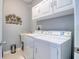 Well-lit laundry room with white appliances, cabinets, and ample space at 1023 Orca Ct, Holiday, FL 34691