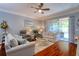 Cozy living room with hardwood floors, ceiling fan, and sliders to the lanai at 1023 Orca Ct, Holiday, FL 34691