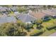 Aerial view of a single story home with screened-in porch overlooking green backyard with landscaping at 10809 Collar Dr, San Antonio, FL 33576