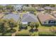 Aerial view of single story home with screened-in porch and lush backyard with privacy hedge at 10809 Collar Dr, San Antonio, FL 33576