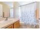 Cozy bathroom featuring a sink, toilet, and shower with patterned shower curtain at 10809 Collar Dr, San Antonio, FL 33576