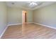 Spacious bedroom with wood-look floors, neutral walls and a tray ceiling with fan at 10809 Collar Dr, San Antonio, FL 33576