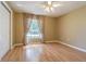 Bedroom with wood-look floors and neutral walls with a large window with curtains at 10809 Collar Dr, San Antonio, FL 33576