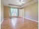 Spacious bedroom with wood floors, tray ceiling, and bright window with curtains at 10809 Collar Dr, San Antonio, FL 33576