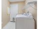 Laundry room with white washer and dryer, wire rack shelving, and access door at 10809 Collar Dr, San Antonio, FL 33576