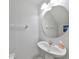 Well-lit half bathroom featuring a modern round mirror and pedestal sink at 10947 Verawood Dr, Riverview, FL 33579