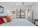 Bright bedroom with a comfortable bed, side table with a lamp, and a view of the outdoors at 110 Parkside Colony Dr, Tarpon Springs, FL 34689