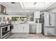 Well-lit kitchen featuring stainless steel appliances, white cabinetry, and modern fixtures at 110 Parkside Colony Dr, Tarpon Springs, FL 34689