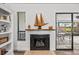 Bright living room featuring a decorative fireplace with mantel, white built-ins, and access to the patio at 110 Parkside Colony Dr, Tarpon Springs, FL 34689