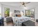 Sun-filled main bedroom with a ceiling fan, hardwood floors, a comfortable bed, and access to the lanai at 110 Parkside Colony Dr, Tarpon Springs, FL 34689
