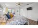 Bright main bedroom with ceiling fan, TV, and sliding glass doors to patio at 110 Parkside Colony Dr, Tarpon Springs, FL 34689