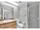 Bright bathroom featuring a single sink vanity, toilet, and glass-enclosed shower stall at 11797 David Ct, Largo, FL 33778