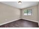 This bedroom features wood floors, a window for natural light, and neutral paint colors at 11797 David Ct, Largo, FL 33778