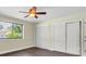 This bedroom features wood floors, a ceiling fan, and a closet with sliding doors at 11797 David Ct, Largo, FL 33778