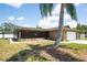 Single story home with screened in porch and a large palm tree at 11797 David Ct, Largo, FL 33778