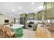 The kitchen showcases stainless steel appliances, green cabinets and stylish tile flooring at 11797 David Ct, Largo, FL 33778