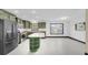 Bright kitchen features modern stainless steel appliances, green cabinets, and a center island at 11797 David Ct, Largo, FL 33778
