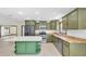 Bright kitchen featuring green cabinets, stainless steel appliances, and a center island at 11797 David Ct, Largo, FL 33778