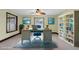 This home office features a ceiling fan, built-in bookshelves and lots of light at 11797 David Ct, Largo, FL 33778