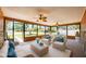 The enclosed lanai features large windows, comfortable seating, and lots of light at 11797 David Ct, Largo, FL 33778