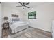 Bright bedroom features luxury vinyl flooring, ceiling fan, and window with backyard view at 120 12Th N Ave, Safety Harbor, FL 34695