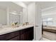 Bathroom featuring a double sink vanity with a dark wood finish and a view into the bedroom at 12168 Lily Magnolia Ln, Riverview, FL 33569