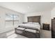Bright bedroom with a large window, neutral walls, and a gray, cushioned bench at the foot of the bed at 12168 Lily Magnolia Ln, Riverview, FL 33569
