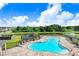 Aerial view of community pool with lounge chairs, a playground, and a lush green landscape at 12168 Lily Magnolia Ln, Riverview, FL 33569