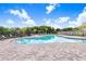 Community pool with lounge chairs, a playground, and palm trees against a blue sky at 12168 Lily Magnolia Ln, Riverview, FL 33569