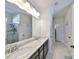Bright bathroom featuring a double vanity with granite countertop, large mirror, and tiled floor at 12206 Blue Pacific Dr, Riverview, FL 33579