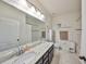 Bright bathroom featuring a vanity with granite countertop, large mirror, and tiled floor at 12206 Blue Pacific Dr, Riverview, FL 33579