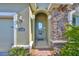 Close-up of the home's entrance showcasing stone accents, a modern light fixture and address numbers at 12206 Blue Pacific Dr, Riverview, FL 33579