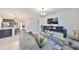 Open-concept living room with tile flooring, modern decor, and easy access to the kitchen and dining areas at 12206 Blue Pacific Dr, Riverview, FL 33579