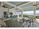 Outdoor lounge with a fireplace, ceiling fans, comfortable seating, and lake views, perfect for relaxing and entertaining at 12206 Blue Pacific Dr, Riverview, FL 33579