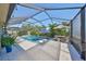 The screened-in pool area has ample seating, mature landscaping, and a sparkling pool at 12206 Blue Pacific Dr, Riverview, FL 33579