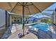 Relaxing outdoor space featuring a screened-in pool, patio seating, and a built-in grill at 12206 Blue Pacific Dr, Riverview, FL 33579