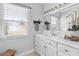 Bathroom with white vanity, large mirror, and natural light from the window at 170 Argus Rd, Venice, FL 34293