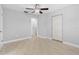 Bright bedroom featuring a ceiling fan, neutral walls, and doorway that leads to an attached bathroom at 170 Argus Rd, Venice, FL 34293