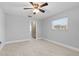 Bright bedroom with light wood floors, ceiling fan, and a door to the bathroom at 170 Argus Rd, Venice, FL 34293